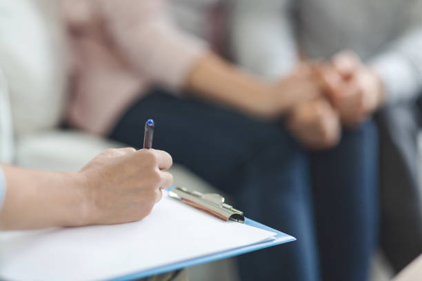 istock Therapist writing in blank notepad at family counseling session 1191636705
