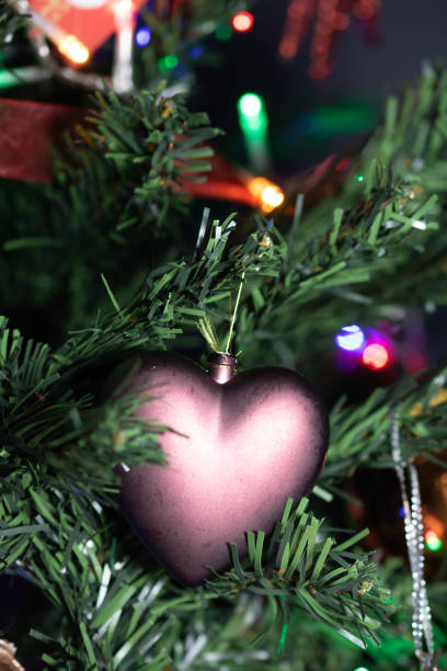 istock Christmas hanging decorations on fir tree. Decorated Christmas tree.  Fir branches with Christmas heart shaped decoration and lights. 1191638159