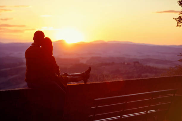 Romantic young man and woman enjoying together on romantic beautiful sunset.