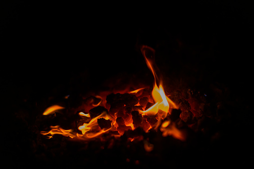 Colorful flames from a hot coal fire in a blacksmith's fireplace close up.