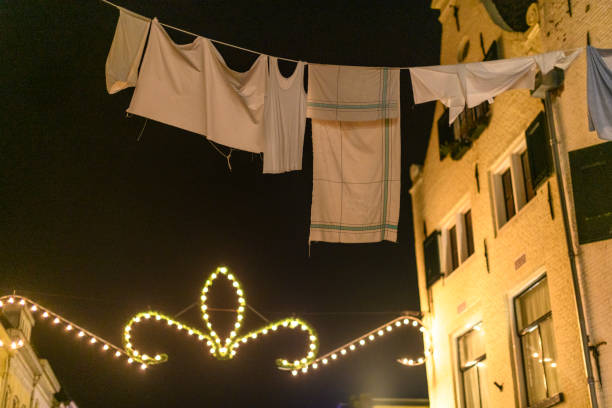 Laundry hanging out to dry as decoration during a Dickens Christmas festival Laundry hanging out to dry as decoration during a Dickens Christmas festival during a cold winter night in December. hanging laundry at night stock pictures, royalty-free photos & images