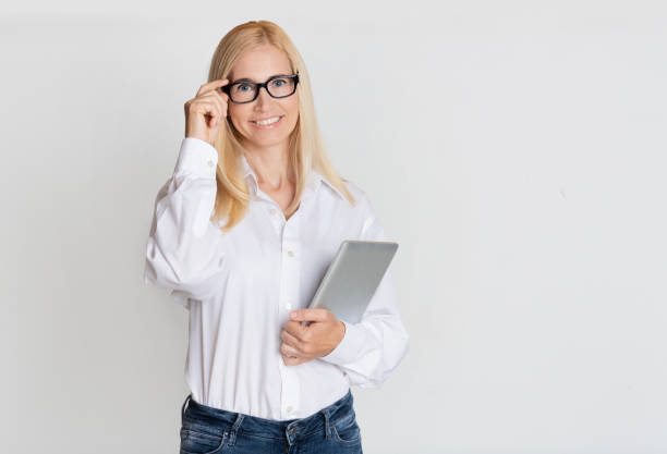 istock Middle-aged business lady with digital tablet at gray background 1191643191