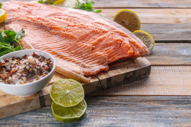 istock Close-up fresh appetizing salmon steak. Spices, lemon, fresh parsley and ice. Rustic background. Organic food. 1191643716