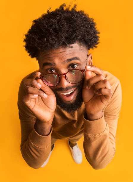 istock Childish black guy watching over glasses at camera 1191643782