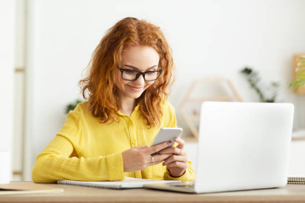 istock Happy businesswoman using smartphone near computer in office 1191645417