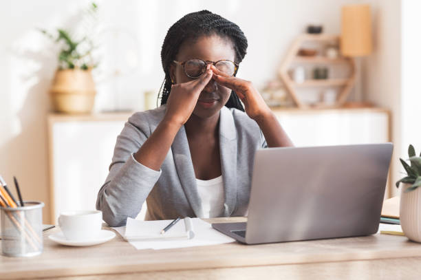 Overworked Black Businesswoman Massaging Nosebridge At Workplace Having Eyesight Problem Eye Strain. Overworked Black Businesswoman Massaging Nosebridge At Workplace Having Eyesight Problem, Selective Focus banging your head against a wall stock pictures, royalty-free photos & images