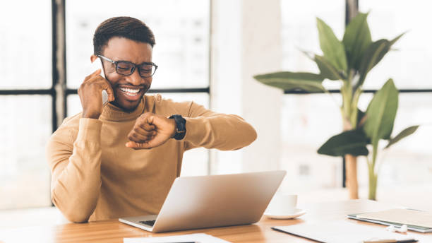 istock Happy black guy looking at watch talking on phone 1191646964