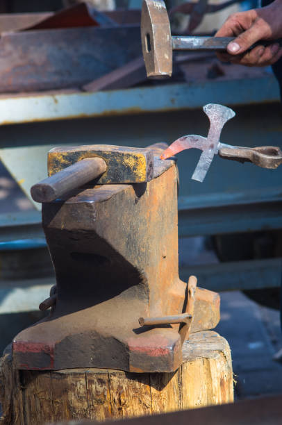 istock blacksmith performs the forging of hot glowing metal on the anvil 1191647347