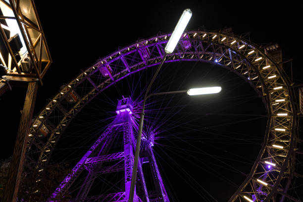istock Looking up at a large purple ferris wheel at night 1191647606