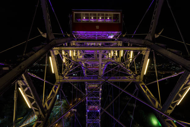 cresta in cima a una ruota panoramica gigante di notte con paesaggio urbano - ferris wheel wheel night neon light foto e immagini stock