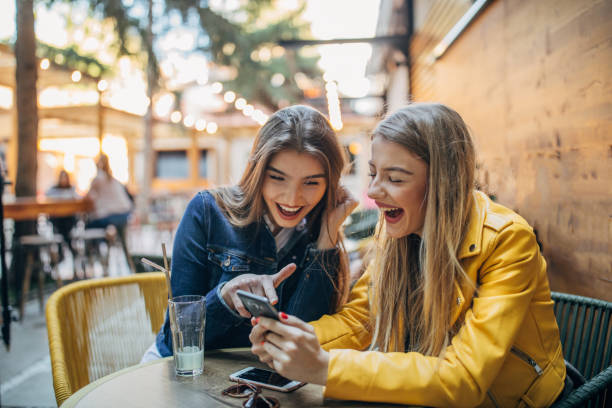 istock Beautfiul ladies using phone outdoors in cafe 1191648678
