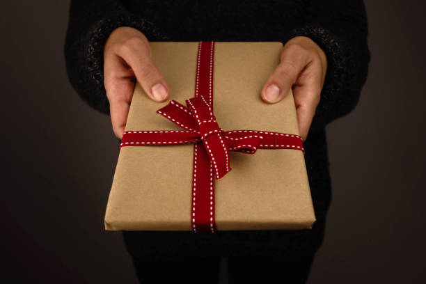 istock Woman with dark sweater holding a gift. 1191648723