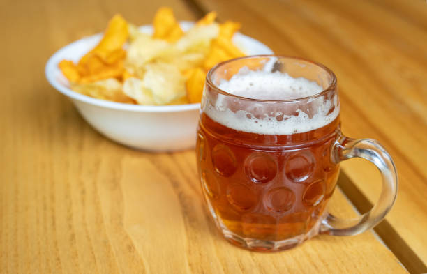 istock Mug with beer and chips on a wooden table. 1191649088