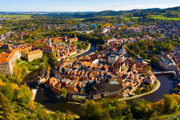Picturesque autumn cityscape of Cesky Krumlov overlooking its historic centre around ancient Castle on bank of Vltava river, Czech Republic