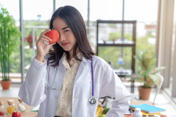 istock Beautiful doctor is showing fruit in the office. 1191650745
