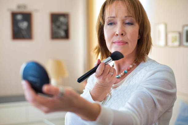istock Mature woman applying makeup while standing in bedroom 1191651658