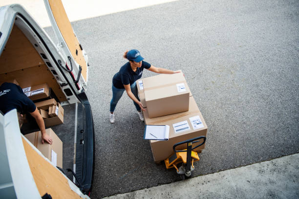 Delivery Workers Loading Delivery Van Delivery Workers  Loading Cardboard Boxes  in Delivery Van loading bay stock pictures, royalty-free photos & images