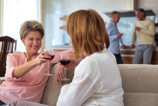 istock Mature women toasting while sitting on sofa at home 1191653656
