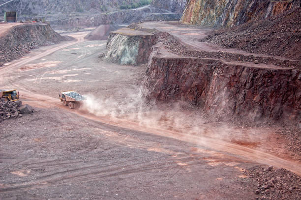 istock Dumper truck with rock material driving through mine. 1191654251