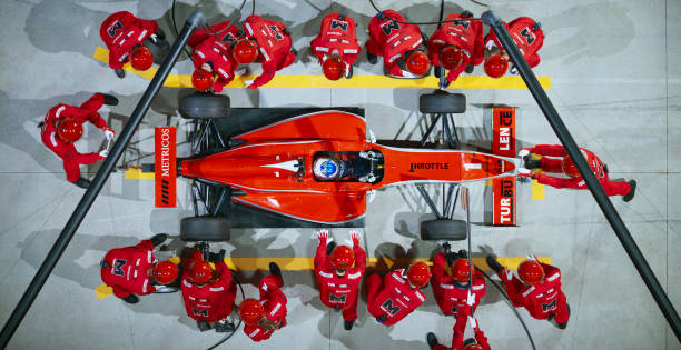 Pit crew working at pit stop Pit crew changing tires of Formula car at pit stop. extreme dedication stock pictures, royalty-free photos & images