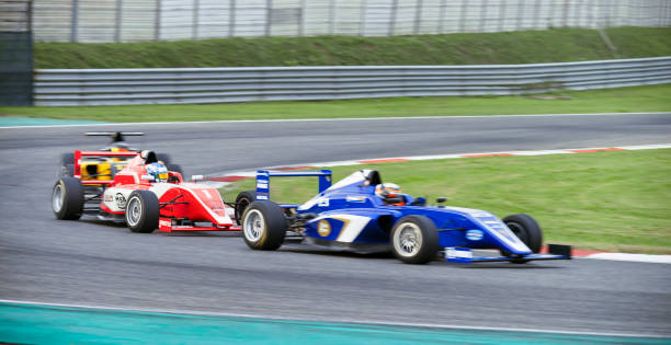 fahrer, die rennwagen fahren - grand prix rennen stock-fotos und bilder