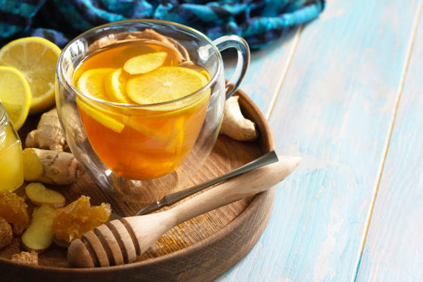 Cup of hot tea with lemon, ginger, honeycomb and honey on a wooden table. Copy space. Cup of hot tea with lemon, ginger, honeycomb and honey on a wooden table. Copy space. ginger health stock pictures, royalty-free photos & images