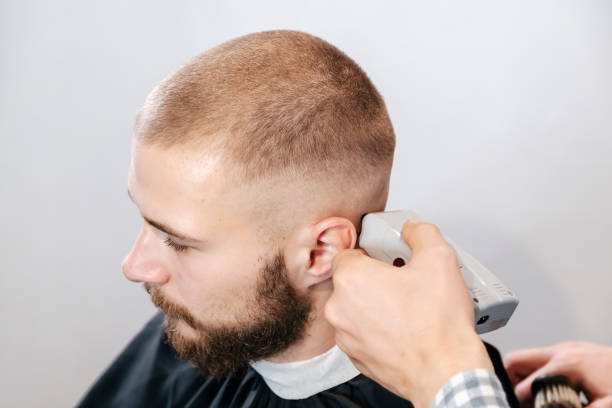 istock Barber shaves the bearded client's head with electric trimmer 1191656929