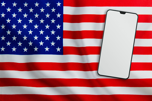 Communication concept. Modern Mobile Phone on Full Frame USA Flag