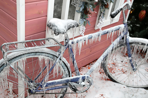 Bicycle parked on Christmas decorations background on a winter street