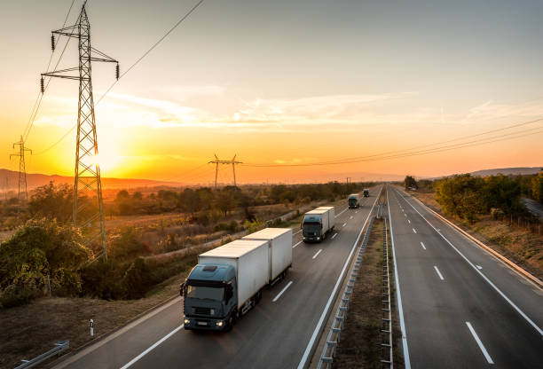 istock Convoy of five blue lorry trucks on a highway 1191665514