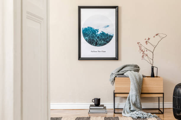 istock Modern scandinavian living room interior with black mock up poster frame, design commode, leaf in vase, black rattan basket, books and elegant accessories. Template. Stylish home decor. 1191666449