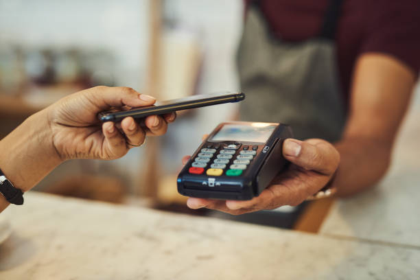 There are many smart ways to manage your money Closeup shot of a customer making a payment with a cellphone in a cafe mobile payment photos stock pictures, royalty-free photos & images