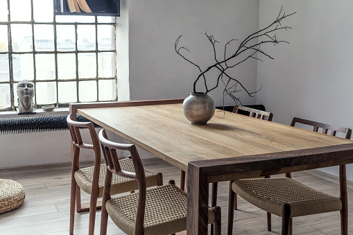 Stylish loft interior design. Open space. Home decor. Wooden table, desk with design accessoreis. Template.