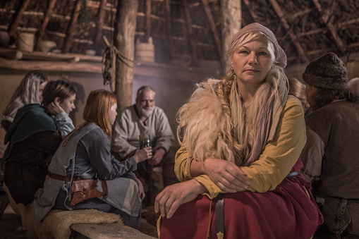 An individual viking female posing for an individual pic in a viking settlement hall