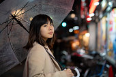 雨の中の若い美しいアジアの女性