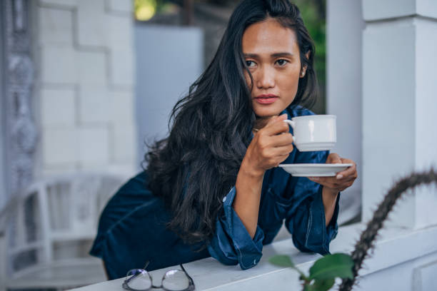 istock Asian lady drinking coffee on the balcony 1191671074