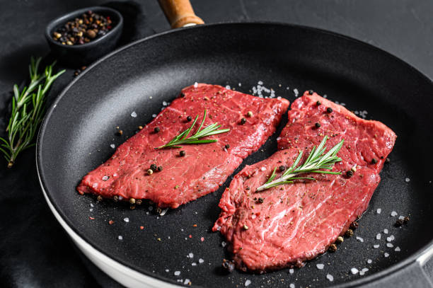 steak de bande de new york cru dans une poêle. de la viande de bœuf. fond noir. vue du haut - steak meat strip steak restaurant photos et images de collection