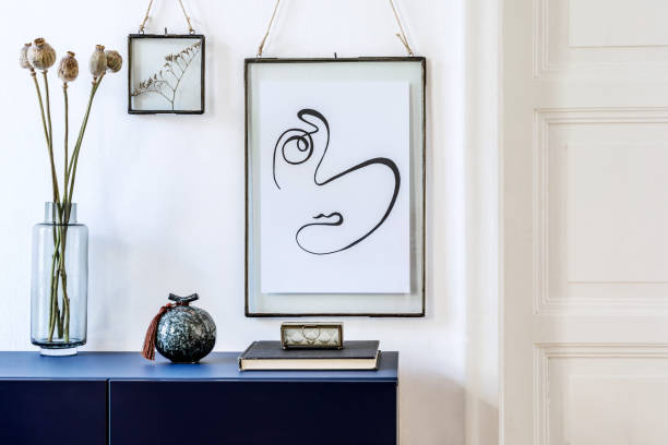 istock Modern scandinavian interior design with mock up photo frames, navy blue commode, flowers in vase and elegant accessories. Stylish home decor. Living room. Template Ready to use. 1191674438