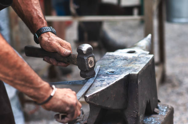 istock An artisan blacksmith knocks with a hammer on iron to shape 1191674878