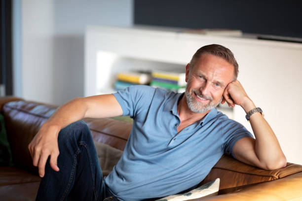 istock handsome smiling  happy mature man relaxing on the sofa 1191674930