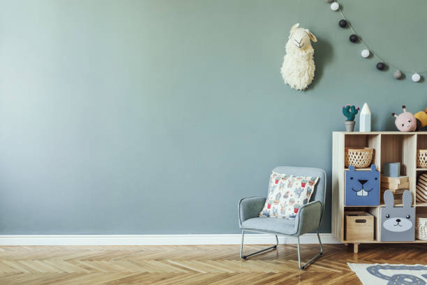 Stylish scandinavian kid room. Design interior of childroom. Template Home decor concept. elegante habitación escandinava recién nacida para bebés con armario de madera, juguetes, silla de menta para niños, cesta natural interior moderno con paredes de fondo de eucalipto, parquet de madera y bolas de algodón. decoración del hogar.