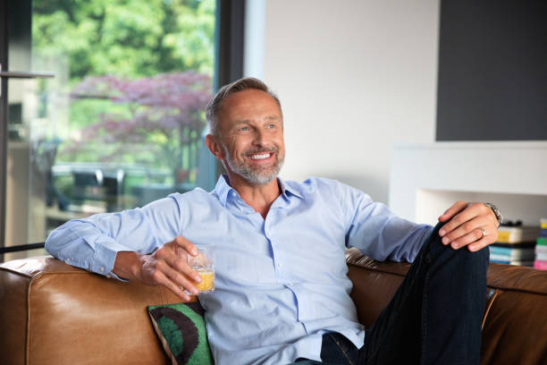 istock handsome smiling  happy mature man relaxing on the sofa 1191675053