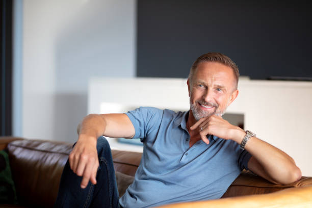 istock handsome smiling  happy mature man relaxing on the sofa 1191675080