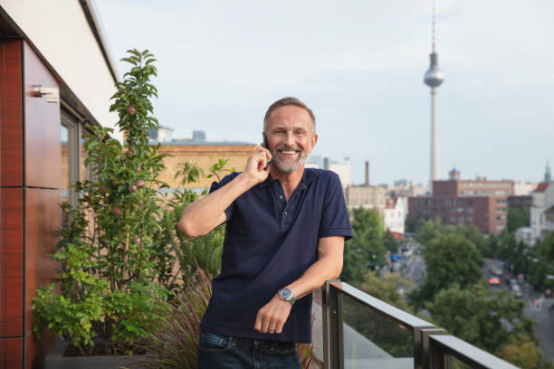 istock Handsome mature man on phone standing on a balcony in Berlin, Germany 1191675169