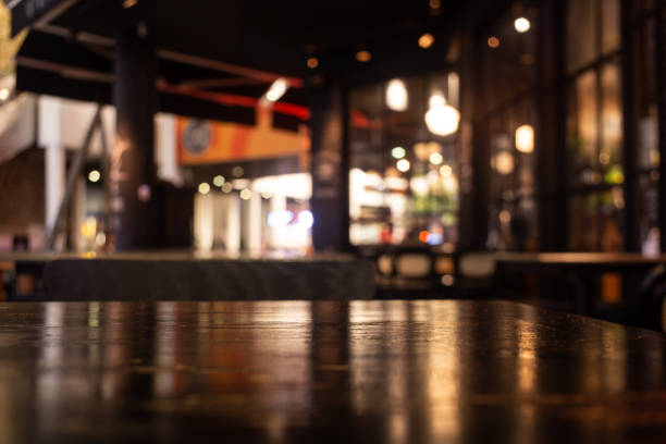 istock Empty real wood table top with light reflection on scene at restaurant, pub or bar at night. 1191675200