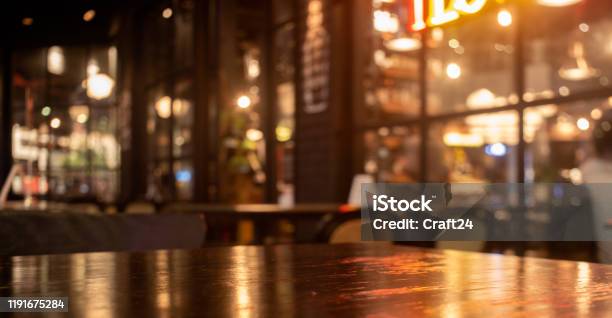 Empty Real Wood Table Top With Light Reflection On Scene At Restaurant Pub Or Bar At Night Stock Photo - Download Image Now