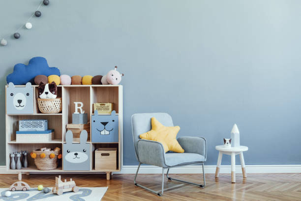 Stylish scandinavian kid room. Design interior of childroom. Template Home decor concept. elegante habitación escandinava recién nacida para bebés con armario de madera, juguetes, silla de menta para niños, cesta natural interior moderno con paredes de fondo de eucalipto, parquet de madera y bolas de algodón. decoración del hogar.