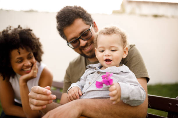 istock Parents sitting on a bench playing with their son 1191676860