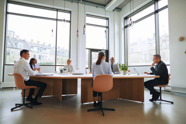istock Diverse businesspeople discussing work while sitting around a boardroom table 1191677511
