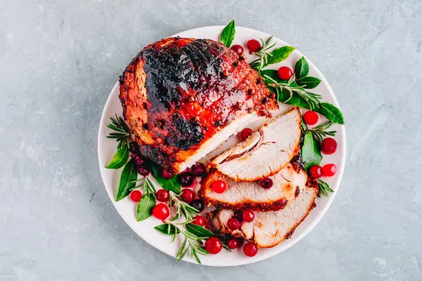 Glazed Ham with cranberry sauce. Roasted Holiday Pork with spices. Top view, copy space.